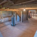 unfinished basement with exposed wooden beams and concrete floors