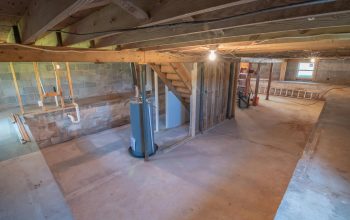 unfinished basement with exposed wooden beams and concrete floors